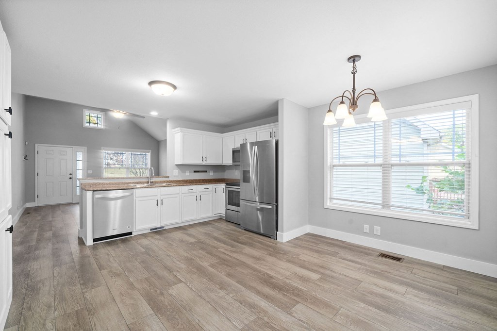 an empty kitchen with white cabinets and stainless steel appliances