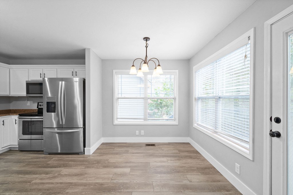 an empty kitchen with stainless steel appliances and a large window