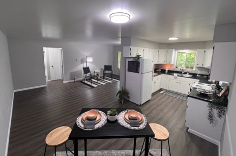A modern kitchen with a dining table set for two.