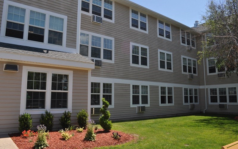 a large apartment building with a yard and grass