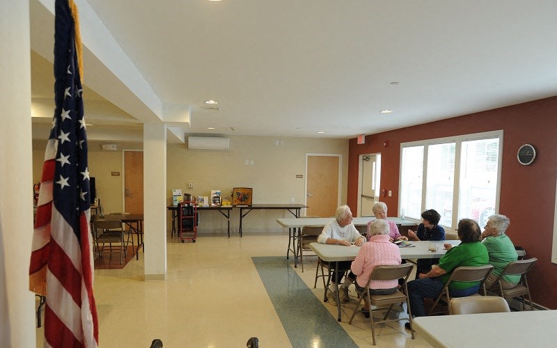 a group of people sitting at tables in a room with an flag