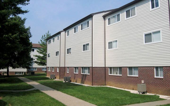 an apartment building with a sidewalk in front of it
