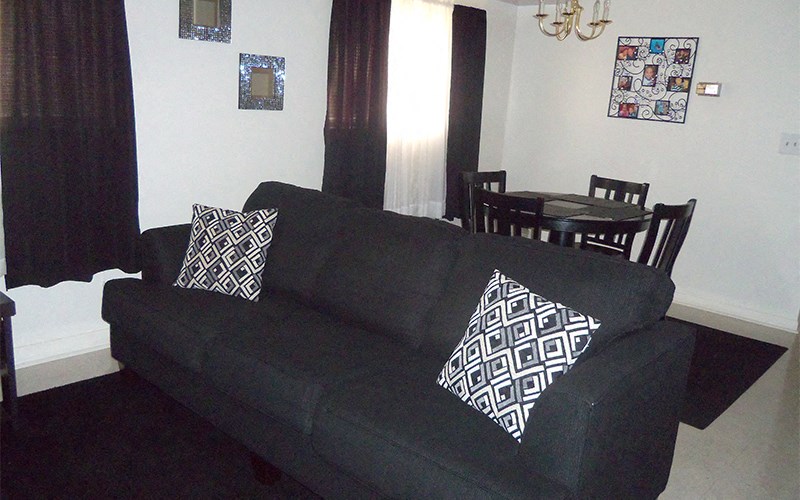 a black couch in a living room with black and white pillows