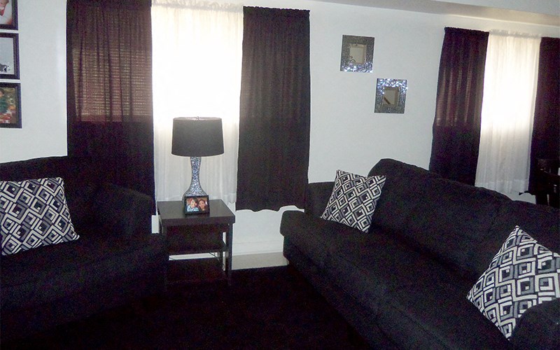 a living room with couches and a table with a lamp
