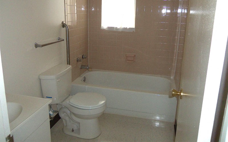 a bathroom with a toilet and a tub and a sink