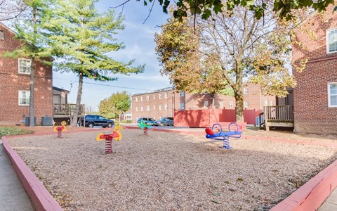 a playground with colorful playground toys in front of a brick building