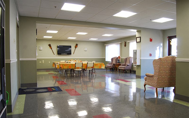 a large room with tables and chairs and a tv in it