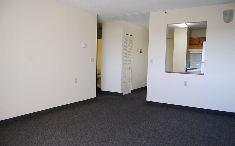 an empty room with white walls and a mirror