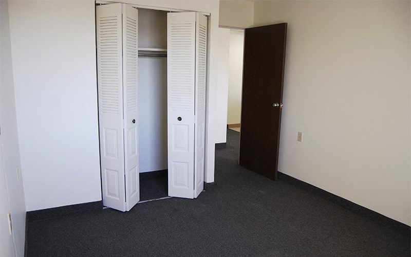an empty room with three closet doors in it