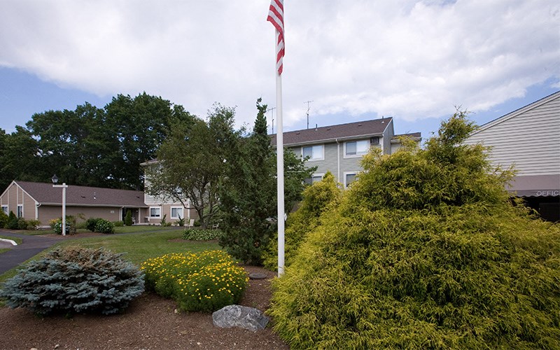 a flag pole with an flag in front of a house