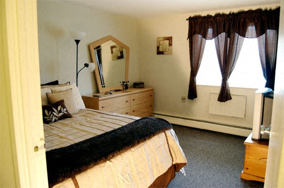 a bedroom with a bed and a dresser and a mirror