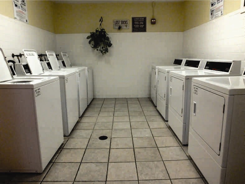 a bunch of washers and dryers in a room