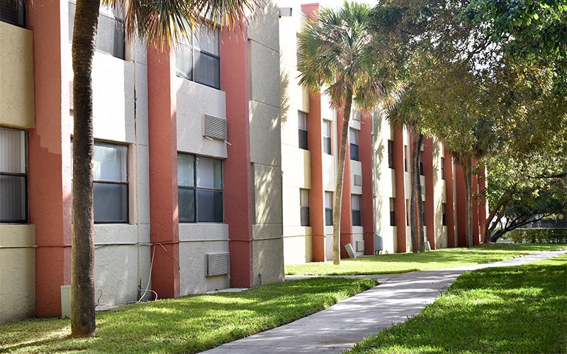 a row of apartment buildings with palm trees