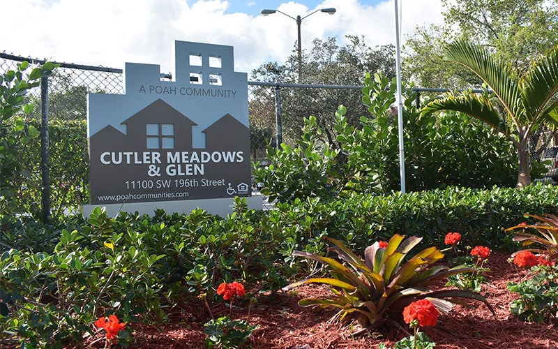 a sign for culter meadows and glen in a garden with flowers