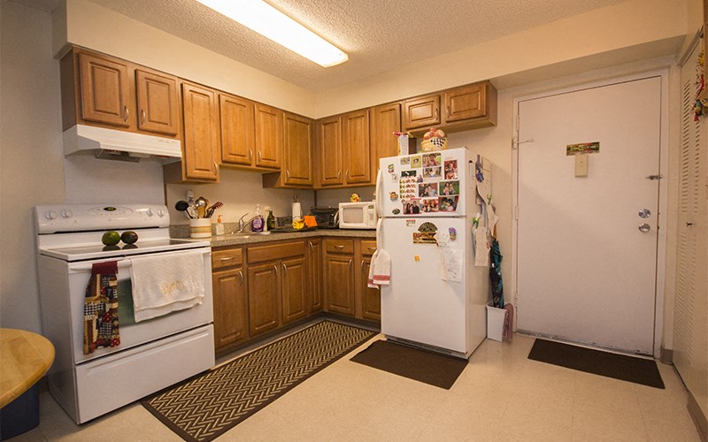 a kitchen with white appliances and wooden cabinets