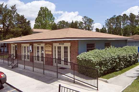 a house with a fenced in porch and a car parked outside