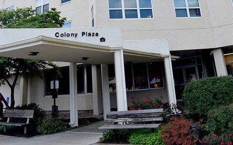 the front of the colony plaza building with two benches