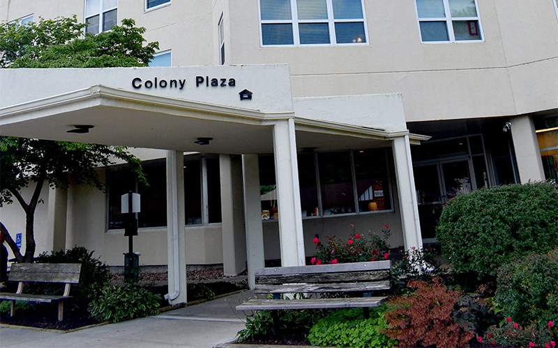 the front of the colony plaza building with two benches