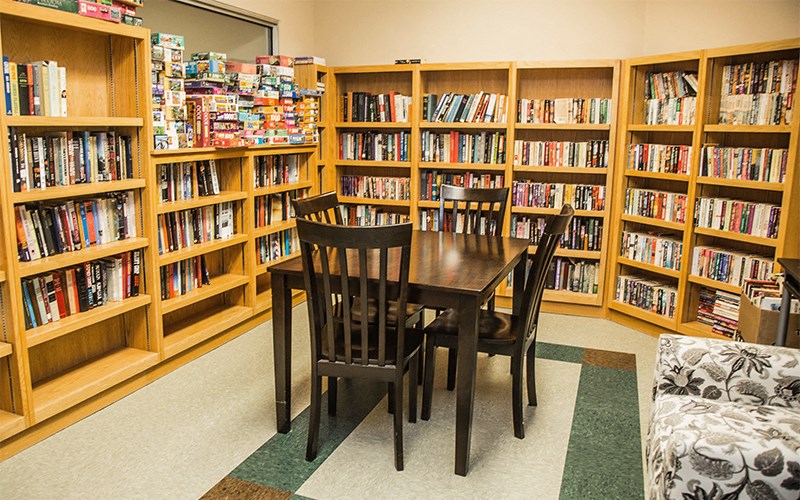 a table and chairs in the middle of a library filled with books