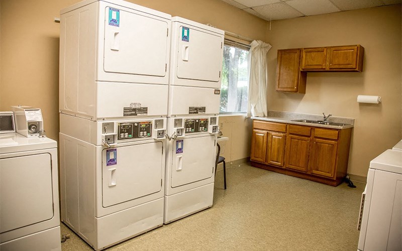 a kitchen with two refrigerators and a sink and a window