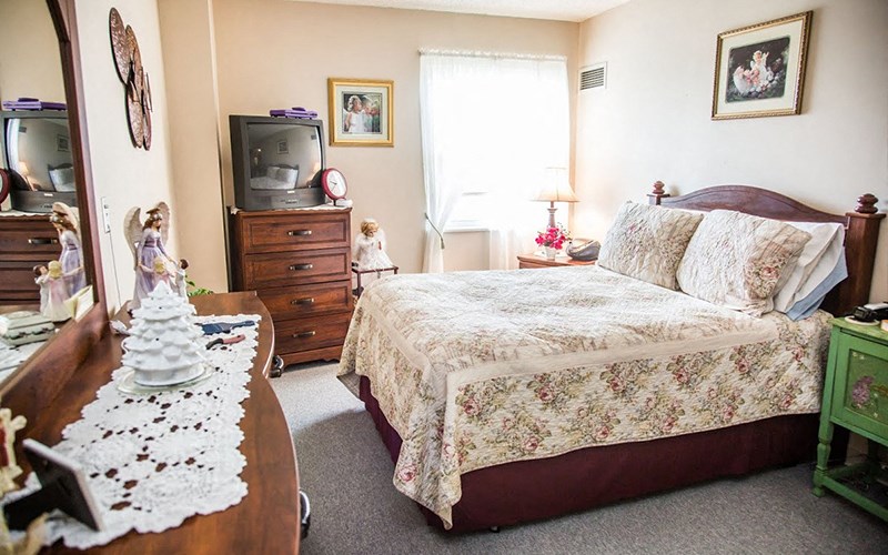 a bedroom with a bed and a dresser and a tv