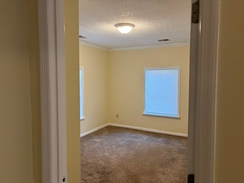 A room with a carpeted floor and a window.