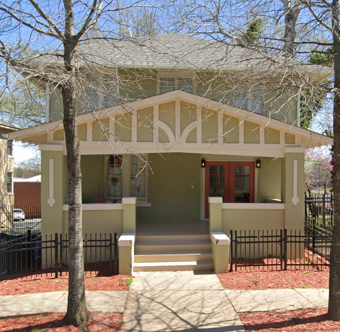 the front of a yellow house with a porch