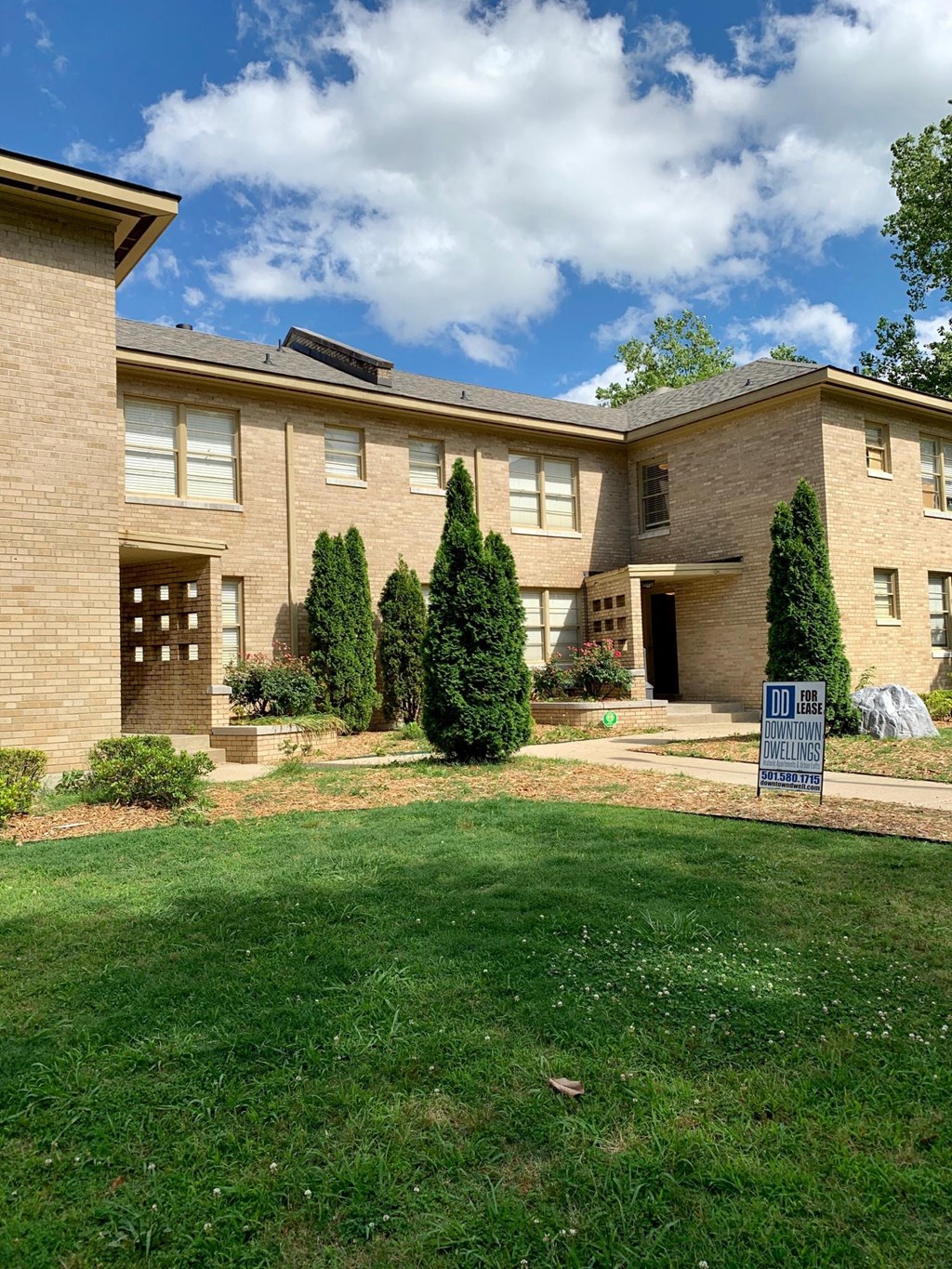 a large brick house with a yard in front of it