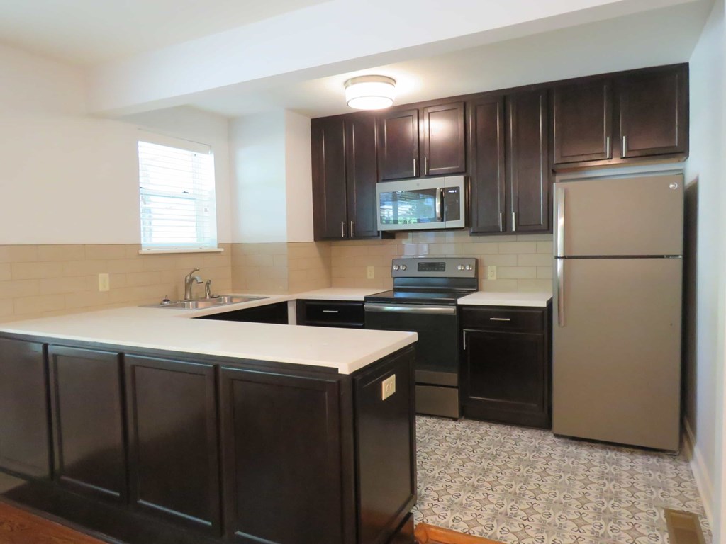 a kitchen with black appliances and white counter tops