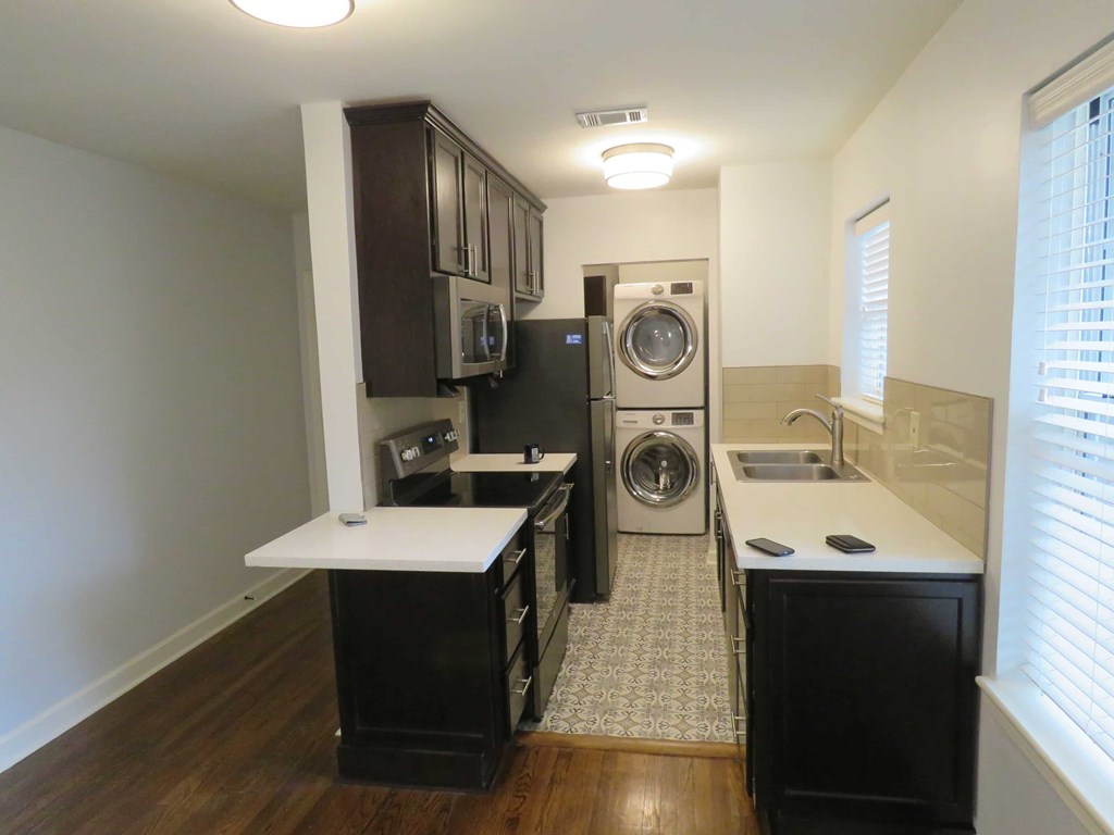 a kitchen with a washer and dryer and a sink and a laundry room