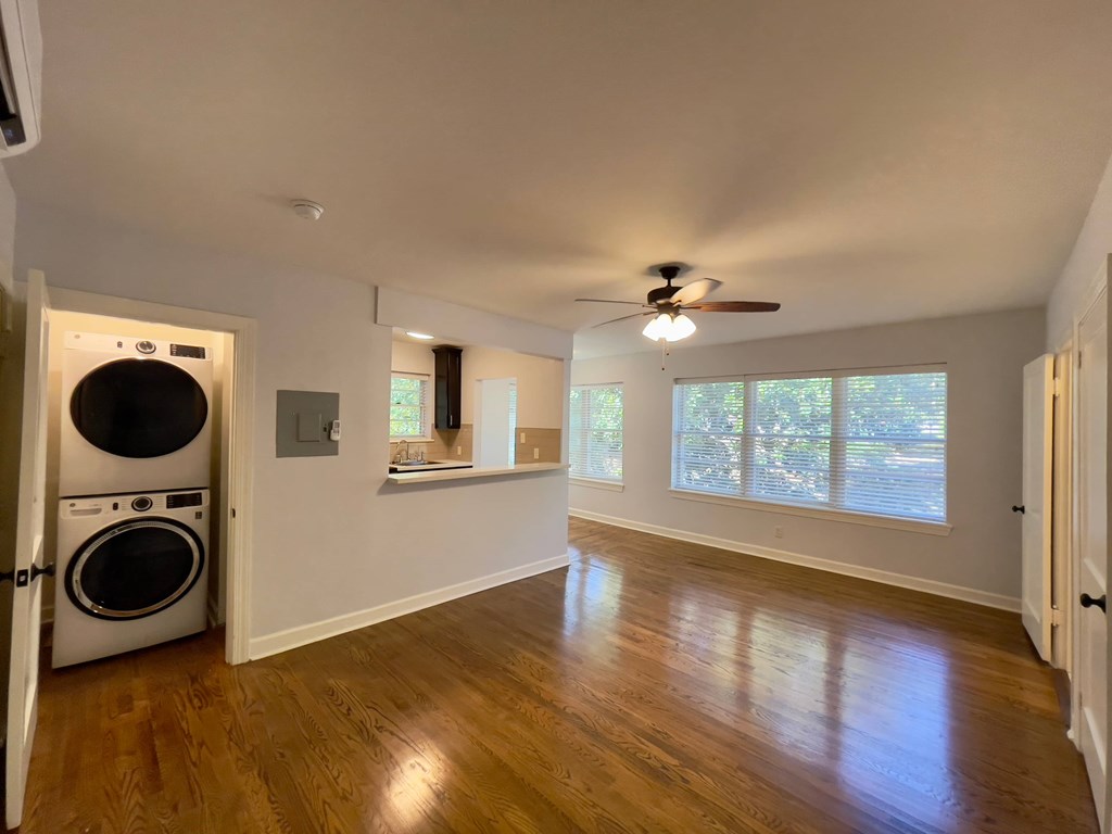 a living room with a washing machine and a ceiling fan