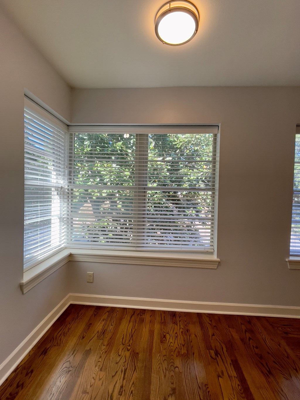 a living room with a large window and a wooden floor