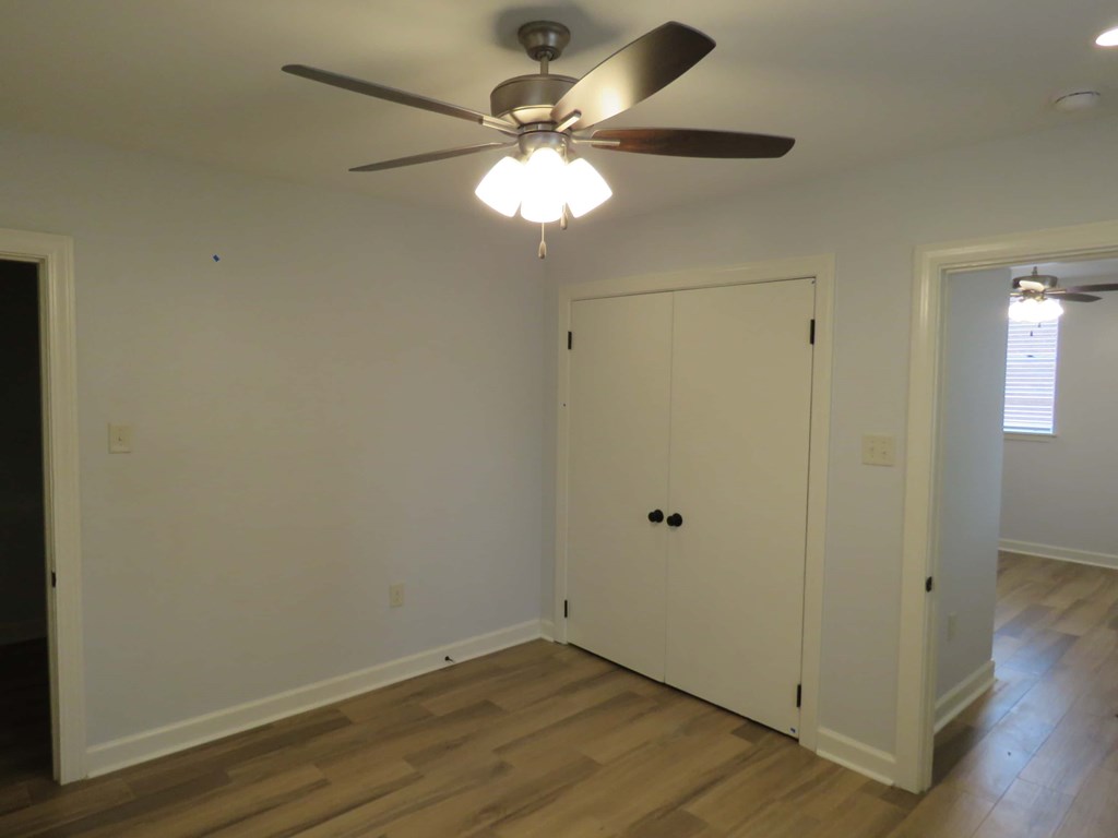 a bedroom with a ceiling fan and a closet