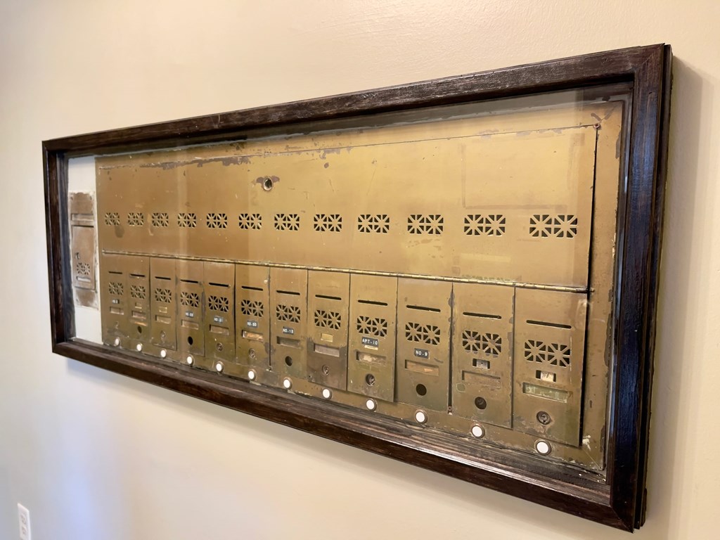 an old machine on the wall with a wooden frame