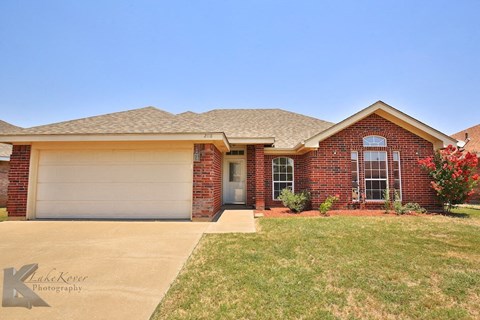 A house with a garage door and a driveway.