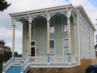the front of a house with a porch and stairs