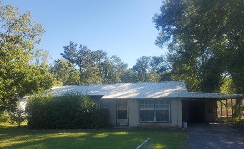a small white house with a metal roof
