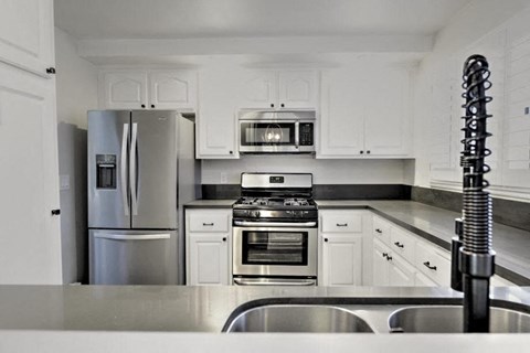 a kitchen with stainless steel appliances and white cabinets
