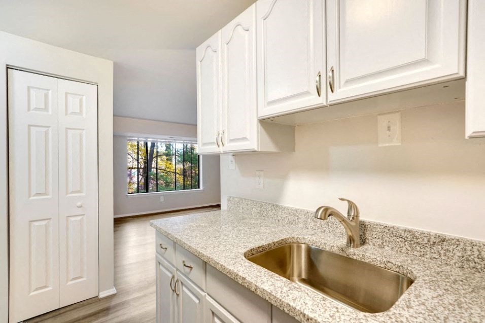 a kitchen with white cabinets and a sink