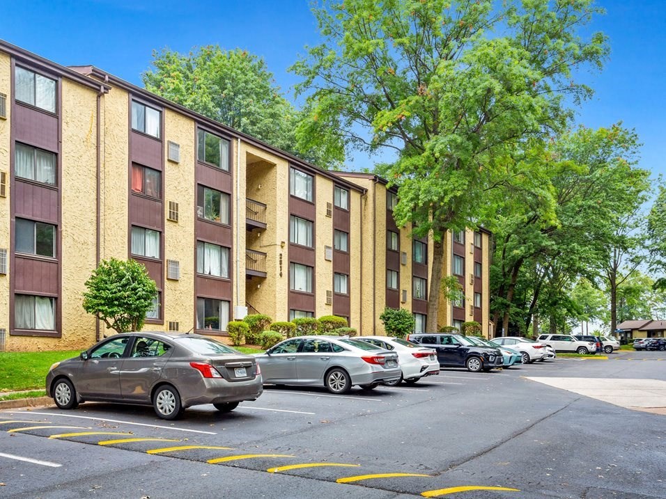 a city street with cars parked in front of an apartment building