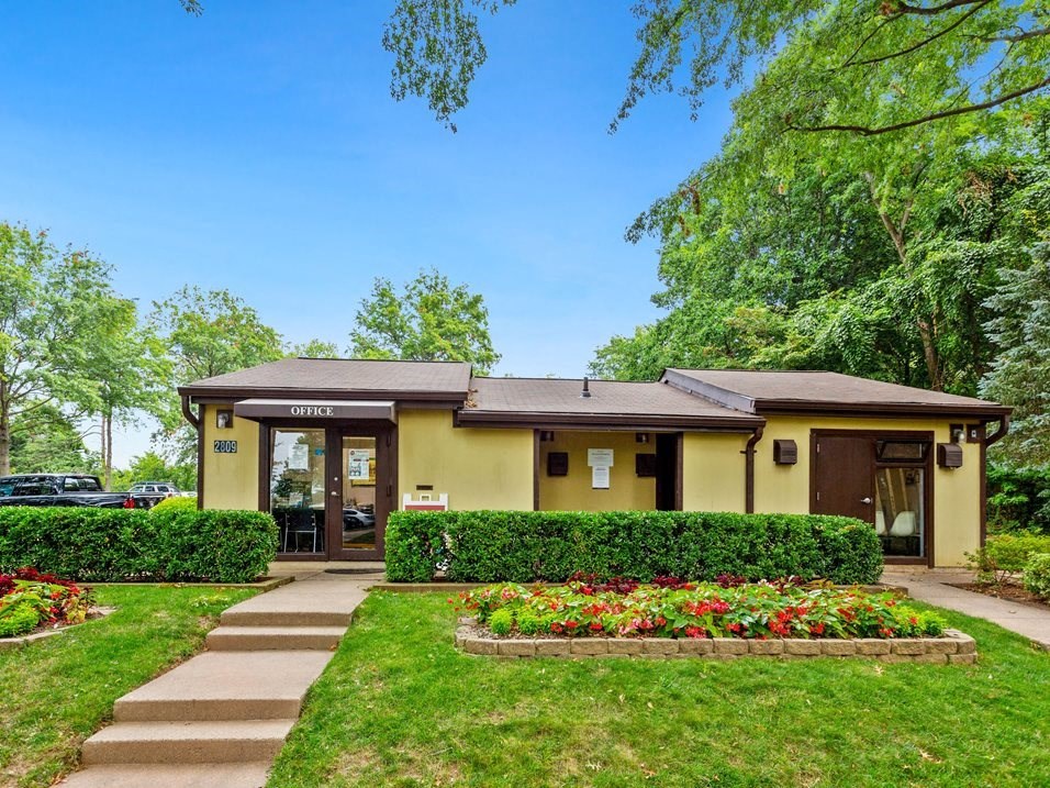the front of a yellow building with a sidewalk in front of it