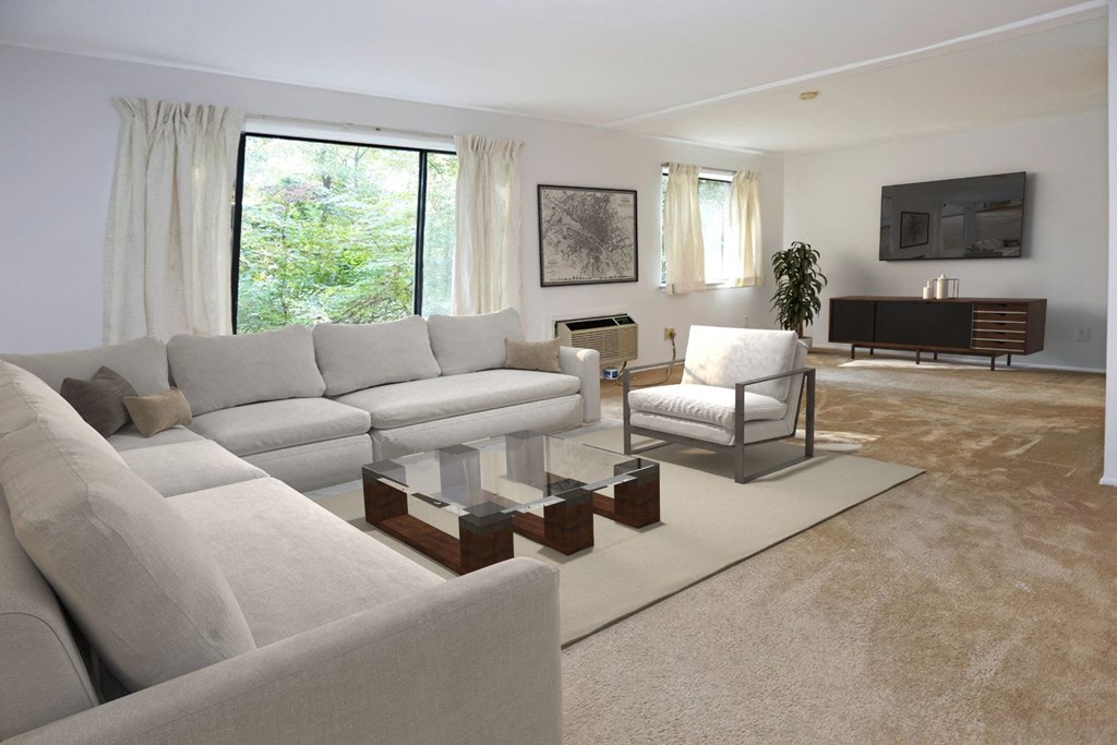 a living room with white couches and chairs and a television