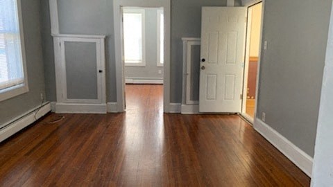 an empty living room with wooden floors and a white door