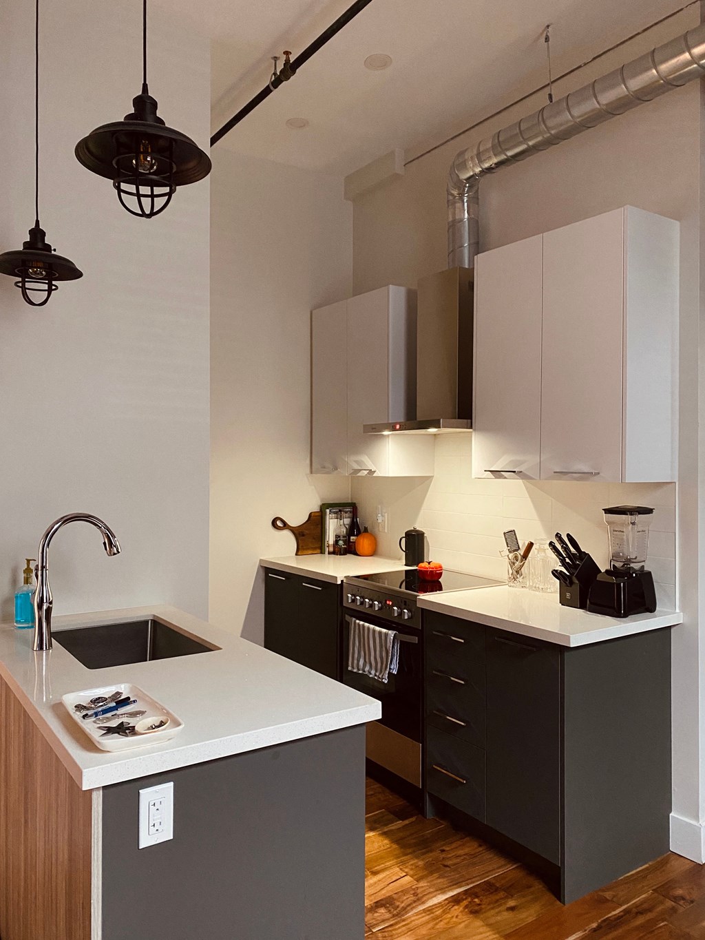 a kitchen with black and white cabinets and a sink