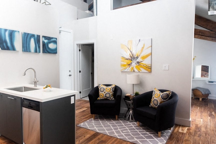 a living room with two black chairs and a sink
