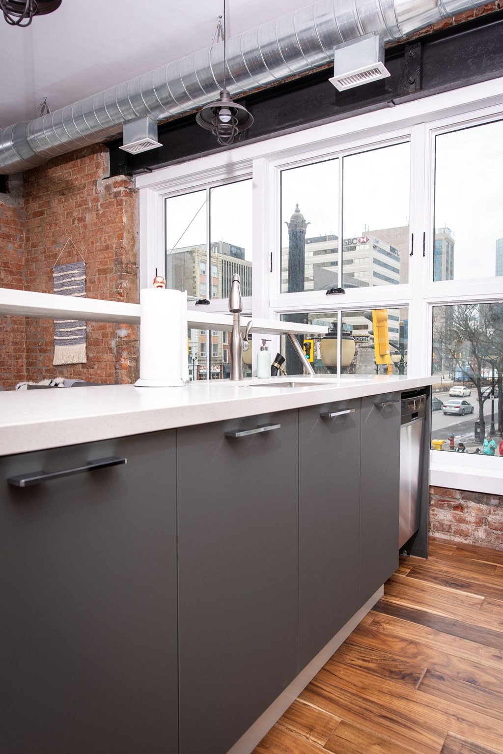 a view of the city from a kitchen with gray cabinets and a window