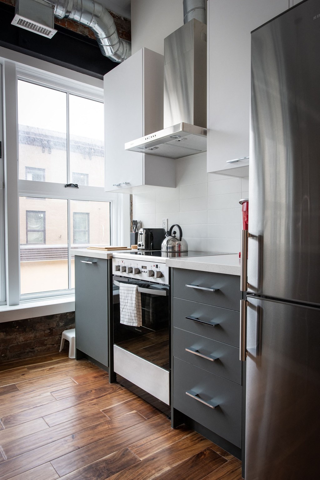 a kitchen with a stainless steel refrigerator and a window