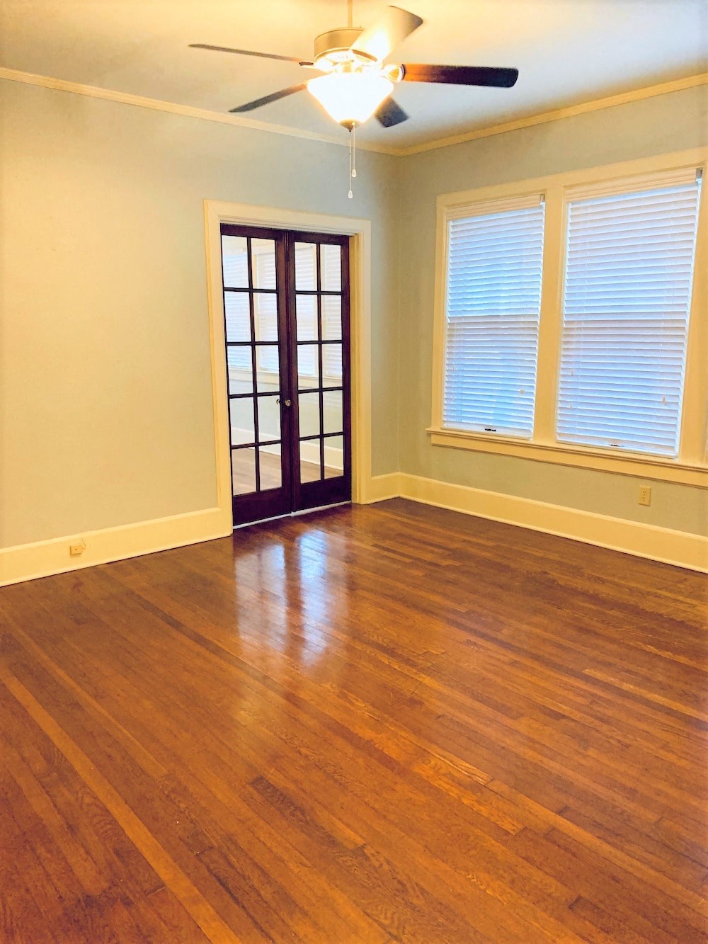 a living room with a hard wood floor and a door