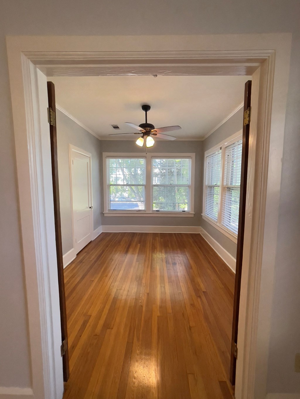an empty room with a ceiling fan and a window
