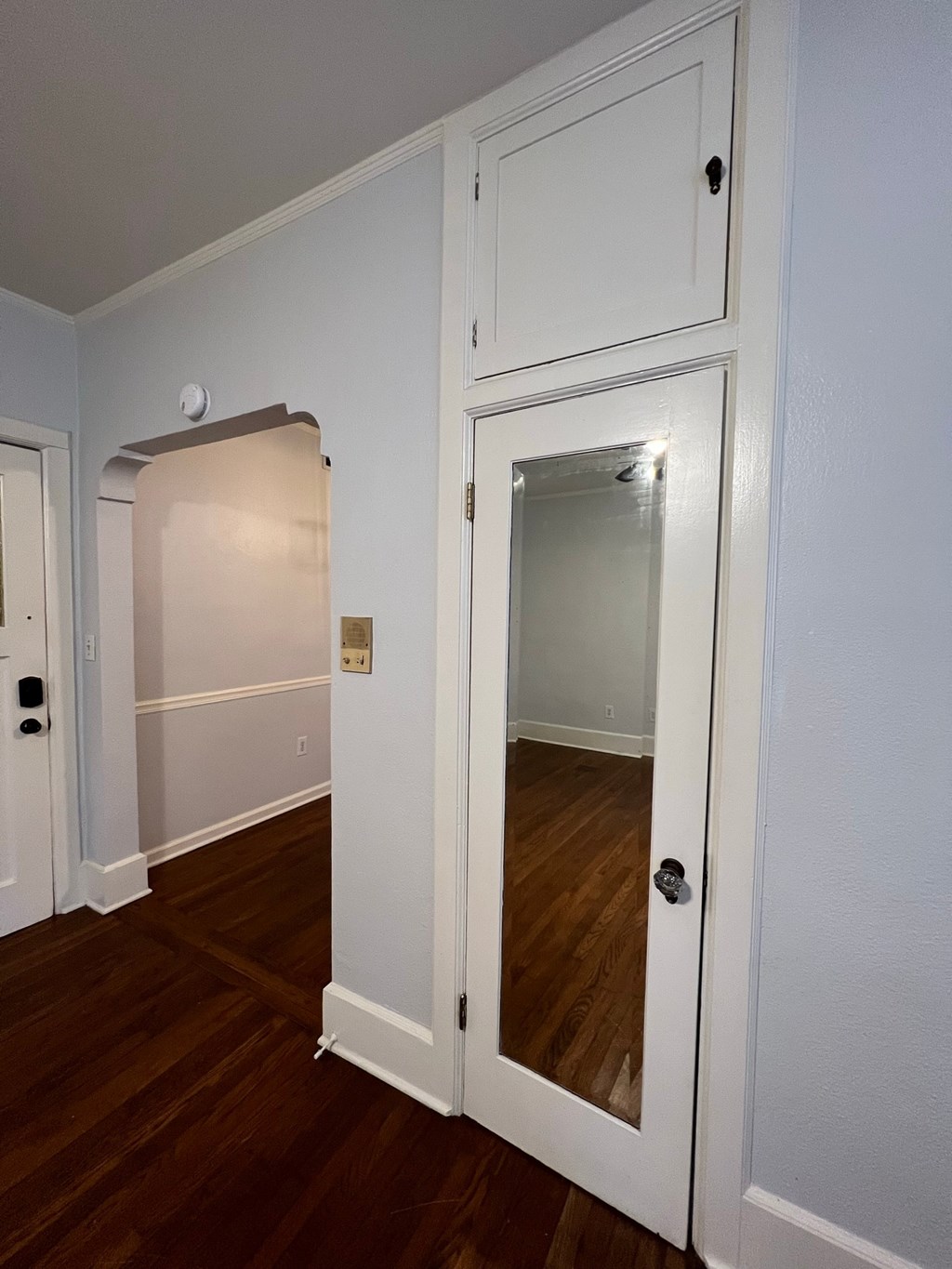 a bedroom with a door to a closet and a mirror